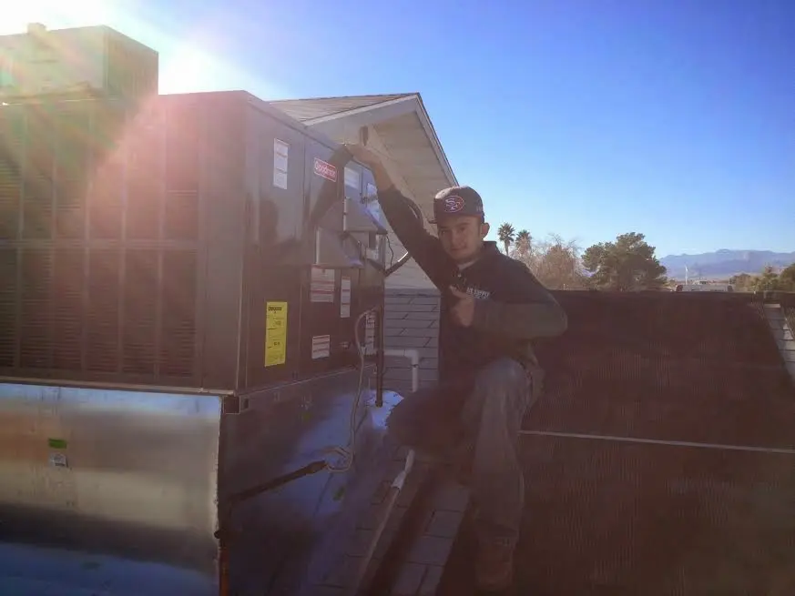 HVAC technician performing AC Tune-Up on a rooftop unit in Andrews